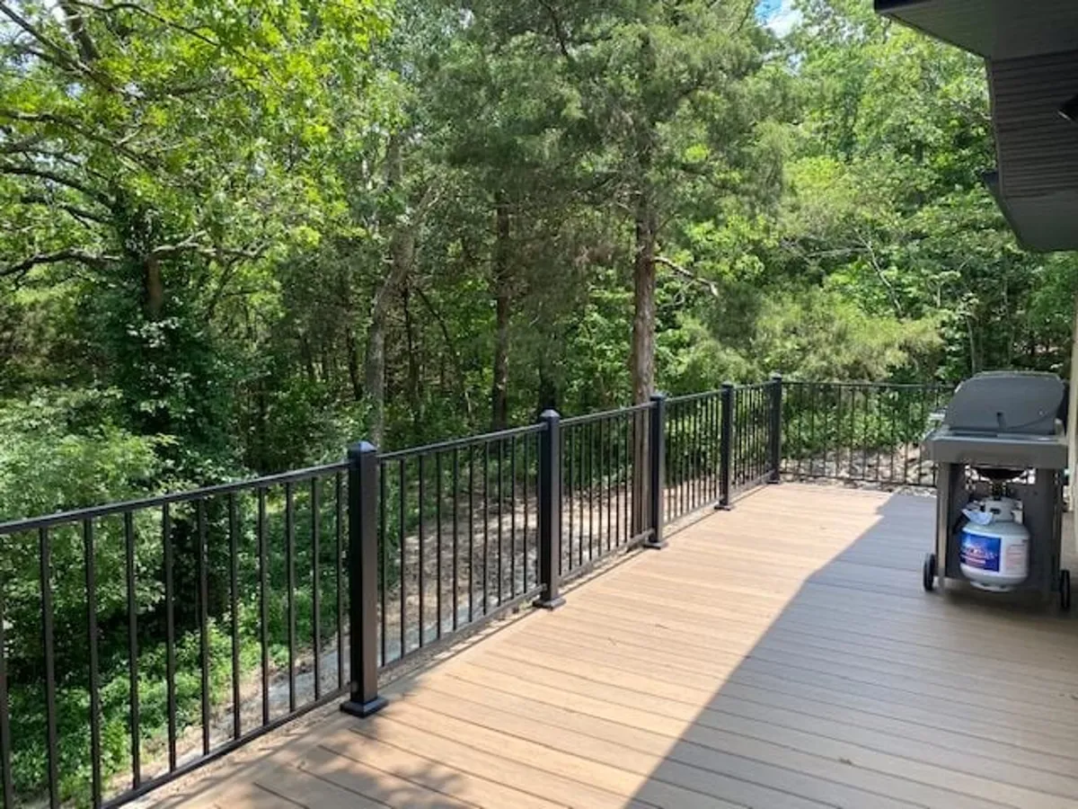 A peaceful deck scene featuring a grill, deck railing, and surrounding trees, perfect for outdoor cooking, barbecues, and relaxed gatherings with friends and family. The setting is calm and private, reinforcing the retreat feel.